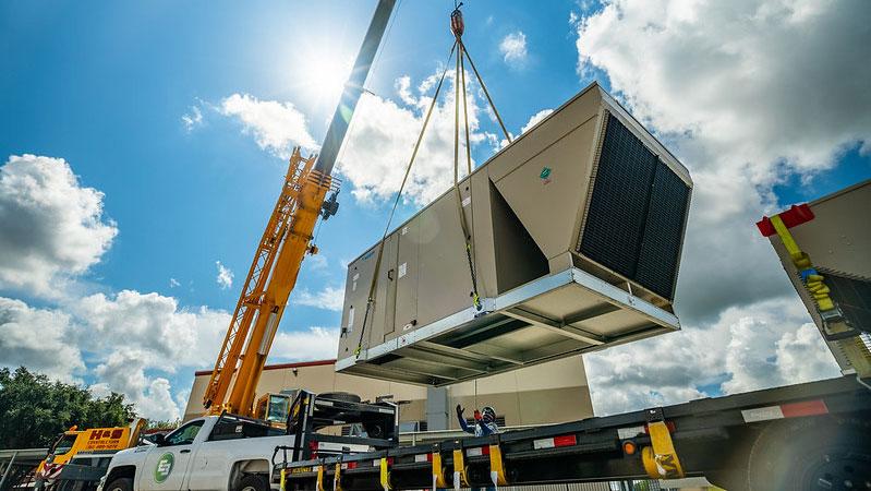 E3 pickup truck at a work site loading up a large outdoor unit